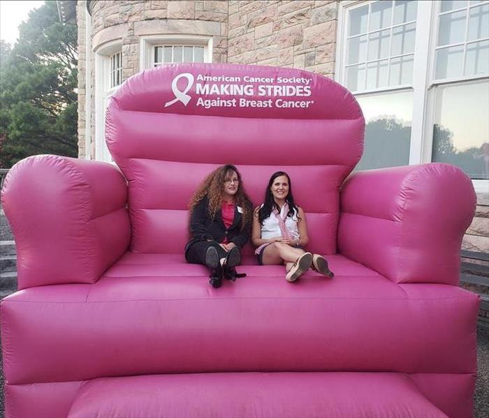 SERVPRO staff sitting on a big pink chair